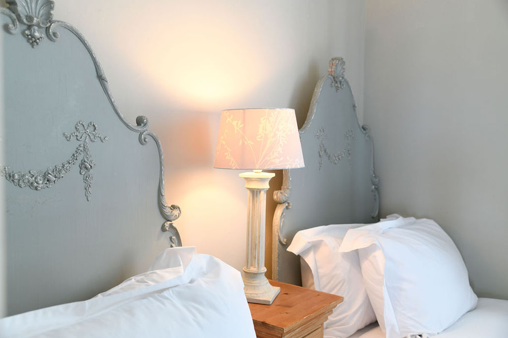 Close-up of duck egg blue headboards with engravings at Lorton House in Dorset